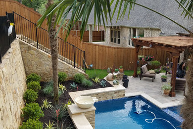 This is an example of a mid-sized traditional backyard rectangular lap pool in Dallas with a water feature and concrete pavers.
