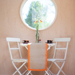 Photo of a small modern home studio in Los Angeles with no fireplace, light hardwood flooring, a built-in desk and white walls.