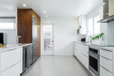 Inspiration for a mid-sized contemporary galley porcelain tile kitchen remodel in Hawaii with an undermount sink, flat-panel cabinets, white cabinets, quartz countertops, stainless steel appliances and a peninsula