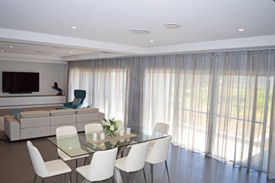This is an example of an expansive contemporary dining room in Sydney with grey walls, porcelain floors and grey floor.