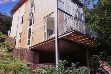 Photo of a contemporary three-storey exterior in Other with wood siding.