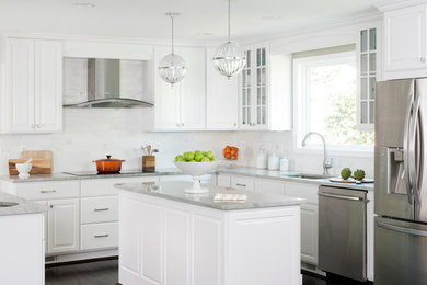 Example of a mid-sized transitional u-shaped brown floor and dark wood floor eat-in kitchen design in DC Metro with white cabinets, white backsplash, stainless steel appliances, an island, an undermount sink and raised-panel cabinets