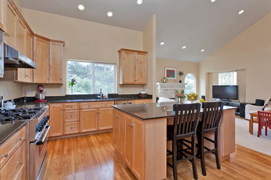 Inspiration for a mid-sized transitional l-shaped medium tone wood floor open concept kitchen remodel in Other with a double-bowl sink, shaker cabinets, medium tone wood cabinets, granite countertops, black backsplash, stainless steel appliances and an island