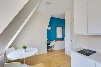 Réalisation d'une petite salle de séjour ouverte avec un mur bleu et parquet clair.