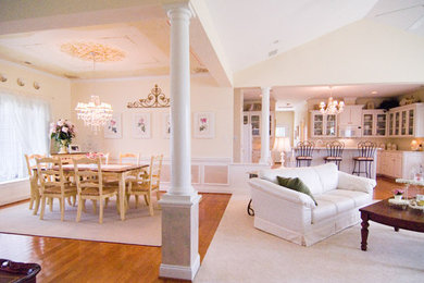 Example of a large classic open concept medium tone wood floor and brown floor living room design in Other with yellow walls