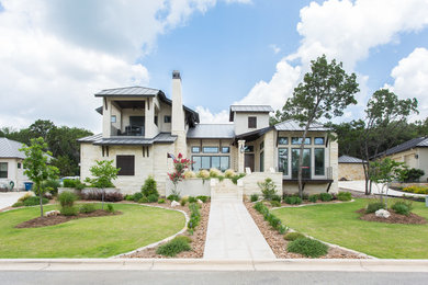Photo of an expansive transitional two-storey white exterior in Austin with stone veneer.