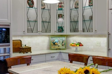 Eat-in kitchen - mid-sized traditional l-shaped eat-in kitchen idea in Charlotte with an undermount sink, recessed-panel cabinets, white cabinets, granite countertops, paneled appliances and an island