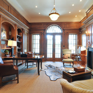 Photo of a large traditional study room in Dallas with brown walls, medium hardwood floors, a standard fireplace, a freestanding desk and a wood fireplace surround.