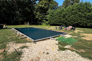 Pool landscaping - large modern backyard concrete paver and rectangular lap pool landscaping idea in New York