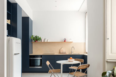 Photo of a medium sized contemporary l-shaped open plan kitchen in Milan with flat-panel cabinets, blue cabinets, concrete worktops, yellow splashback, concrete flooring, no island, grey floors and yellow worktops.