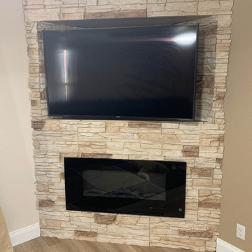 Vanilla Bean Stacked Stone Fireplace Design with the TV Above It