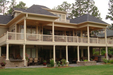 Example of a large classic beige three-story wood gable roof design in Raleigh