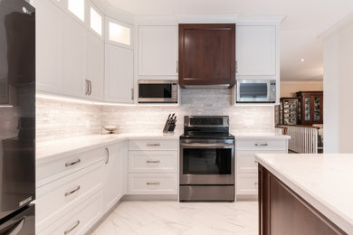 Trendy l-shaped porcelain tile and white floor eat-in kitchen photo in Toronto with shaker cabinets, white cabinets, solid surface countertops, gray backsplash, marble backsplash, stainless steel appliances, an island and white countertops