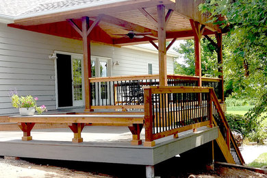 Arts and crafts backyard deck photo in Other with a roof extension