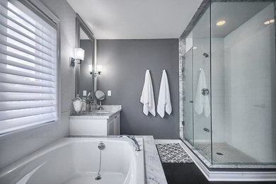 Inspiration for a mid-sized contemporary master white tile and ceramic tile porcelain tile and gray floor drop-in bathtub remodel in Toronto with raised-panel cabinets, white cabinets, a two-piece toilet, gray walls, an undermount sink and marble countertops
