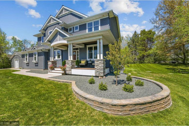 Large arts and crafts blue two-story vinyl exterior home photo in Minneapolis with a shingle roof and a black roof