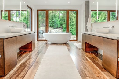 Inspiration for a contemporary medium tone wood floor bathroom remodel in Calgary with flat-panel cabinets, brown cabinets, white walls, a vessel sink and quartzite countertops