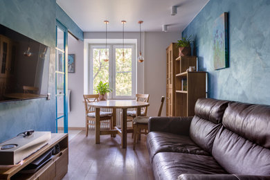 На фото: маленькая объединенная гостиная комната в современном стиле с разноцветными стенами, светлым паркетным полом, телевизором на стене и акцентной стеной для на участке и в саду
