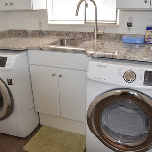 デトロイトの小さいコンテンポラリースタイルのおしゃれな洗濯室 (アンダーカウンターシンク、フラットパネル扉のキャビネット、白いキャビネット、御影石カウンター、合板フローリング、左右配置の洗濯機・乾燥機) の写真