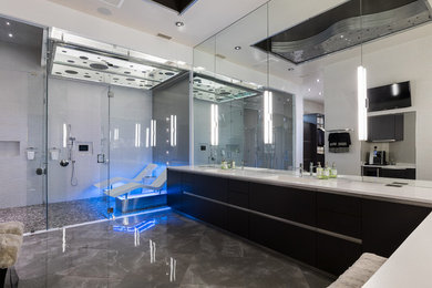 Photo of a large contemporary master bathroom in Dallas with flat-panel cabinets, black cabinets, a corner shower, gray tile, porcelain tile, grey walls, marble floors, an integrated sink, engineered quartz benchtops, grey floor and a hinged shower door.