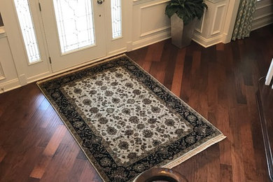 Mid-sized elegant medium tone wood floor and brown floor entryway photo in Baltimore with beige walls and a glass front door
