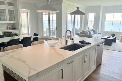 Example of a large transitional single-wall medium tone wood floor open concept kitchen design in Orange County with recessed-panel cabinets, white cabinets, marble countertops, stainless steel appliances, an island and white countertops