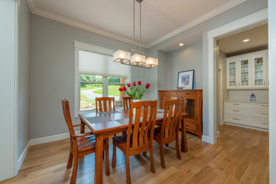 Mid-sized transitional light wood floor and brown floor kitchen/dining room combo photo in Other with gray walls