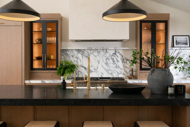 Open concept kitchen - transitional u-shaped light wood floor, brown floor and vaulted ceiling open concept kitchen idea in Orange County with a farmhouse sink, flat-panel cabinets, light wood cabinets, marble countertops, multicolored backsplash, marble backsplash, stainless steel appliances, an island and multicolored countertops
