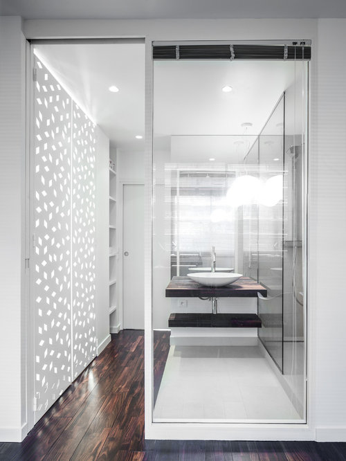 Réalisation d'une petite salle de bain design avec une vasque, un placard sans porte, des portes de placard en bois sombre, un mur blanc et un sol en bois foncé.