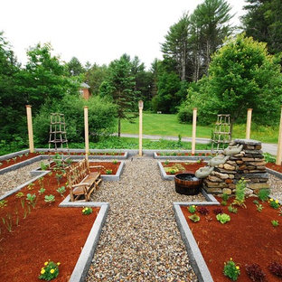 Réalisation d'un grand jardin arrière tradition l'été avec une exposition ensoleillée et des galets de rivière.