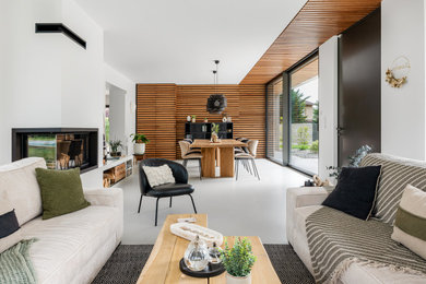 Inspiration pour un très grand salon blanc et bois design avec un mur blanc, sol en béton ciré, une cheminée d'angle, un sol gris, un plafond en bois et du lambris de bois.