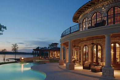 Mediterranean beige stone house exterior idea in Charleston with a tile roof