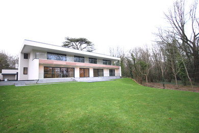 White modern two floor render detached house in Surrey with a flat roof.