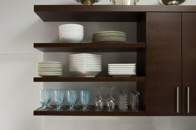 Inspiration for a mid-sized contemporary galley ceramic tile enclosed kitchen remodel in San Francisco with an undermount sink, flat-panel cabinets, dark wood cabinets, quartz countertops, white backsplash, glass sheet backsplash, stainless steel appliances and no island