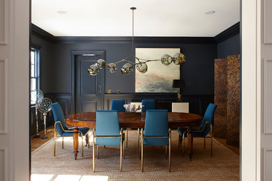 Example of a trendy medium tone wood floor and brown floor enclosed dining room design in New York with black walls