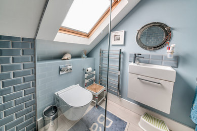 Photo of a small contemporary master bathroom in London with flat-panel cabinets, white cabinets, an open shower, a one-piece toilet, gray tile, ceramic tile, multi-coloured walls, light hardwood floors, a wall-mount sink, beige floor and a hinged shower door.