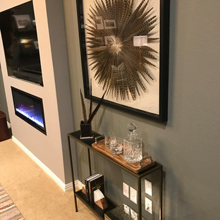 Modelo de despacho rústico, de tamaño medio, con paredes grises, moqueta, chimeneas suspendidas, escritorio independiente y suelo beige