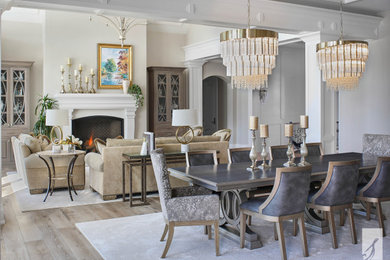 Elegant brown floor, tray ceiling and medium tone wood floor great room photo in Denver with white walls and a standard fireplace