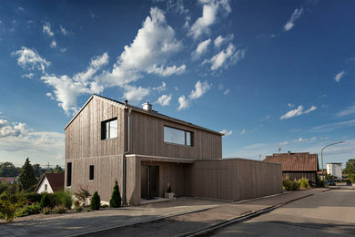 Example of a minimalist brown wood house exterior design in Other