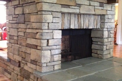 Example of a mid-sized mountain style enclosed light wood floor living room design in Orlando with white walls, a standard fireplace, a stone fireplace and a wall-mounted tv