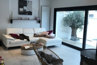 Réalisation d'un salon minimaliste de taille moyenne et ouvert avec un mur blanc, un sol en carrelage de céramique, aucune cheminée, aucun téléviseur et un sol gris.
