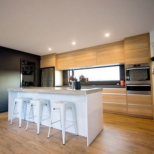 Zweizeilige, Mittelgroße Moderne Küche mit Vorratsschrank, Einbauwaschbecken, Lamellenschränken, hellen Holzschränken, Betonarbeitsplatte, Küchenrückwand in Schwarz, Rückwand aus Keramikfliesen, Küchengeräten aus Edelstahl, hellem Holzboden und Kücheninsel in Hobart