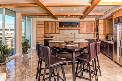Eat-in kitchen - large transitional l-shaped beige floor eat-in kitchen idea in Tampa with beige backsplash, stainless steel appliances, an island and light wood cabinets