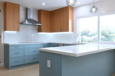 Example of a minimalist u-shaped eat-in kitchen design in Los Angeles with shaker cabinets, blue cabinets and a peninsula