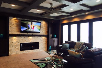 Photo of a large enclosed family room in Other with beige walls, carpet, a standard fireplace, a stone fireplace surround and a wall-mounted tv.