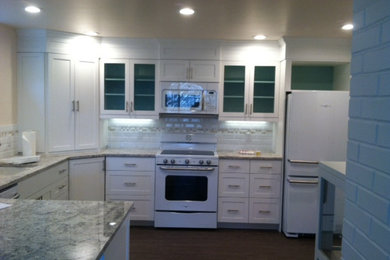 Ejemplo de cocina comedor de estilo americano con armarios con paneles empotrados y puertas de armario blancas