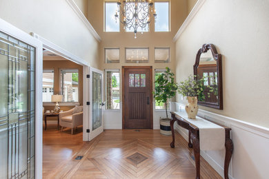 Inspiration for a large transitional entry hall in Sacramento with beige walls, medium hardwood floors, a single front door, a dark wood front door and brown floor.