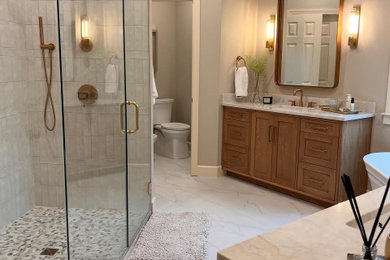 Freestanding bathtub - mid-sized transitional master beige tile and porcelain tile ceramic tile, beige floor and double-sink freestanding bathtub idea in Atlanta with shaker cabinets, brown cabinets, a bidet, beige walls, an undermount sink, quartzite countertops, a hinged shower door, beige countertops, a niche and a built-in vanity