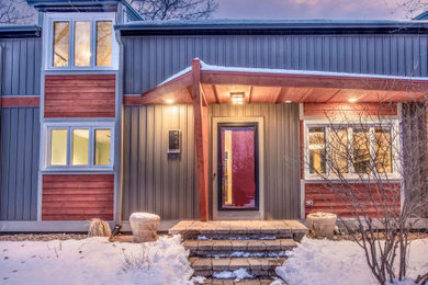 Mid-sized eclectic red two-story vinyl exterior home idea in Other with a shingle roof