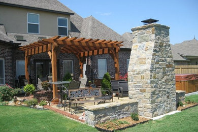 Inspiration for a mid-sized rustic full sun backyard stone formal garden in Other with a fire pit.